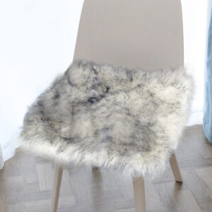 A white color with gray tip sheepskin cushion sits on the chair.