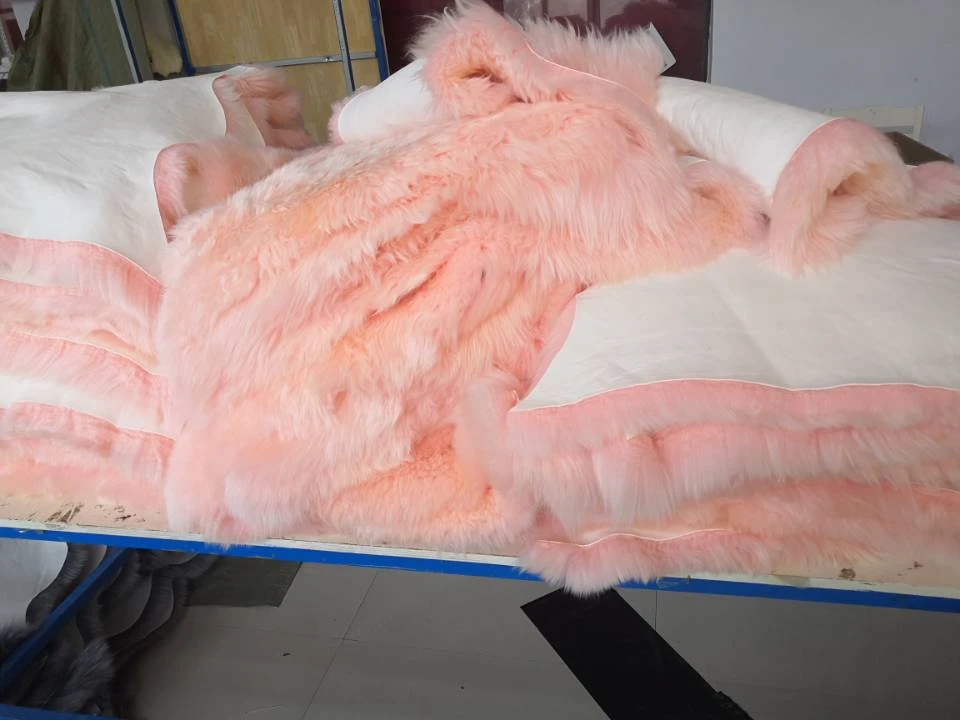 There was a pile of pink sheepskin rugs on the table.