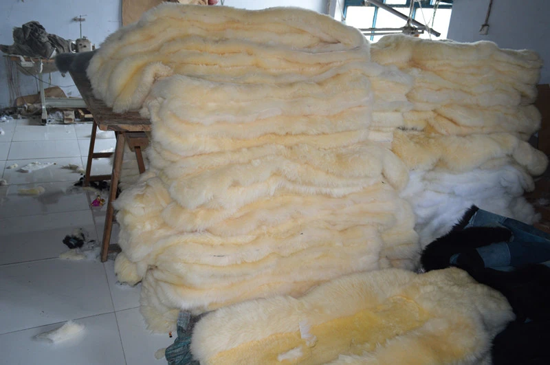 Beige long and low wool sheepskin car seat covers stacked together in the warehouse