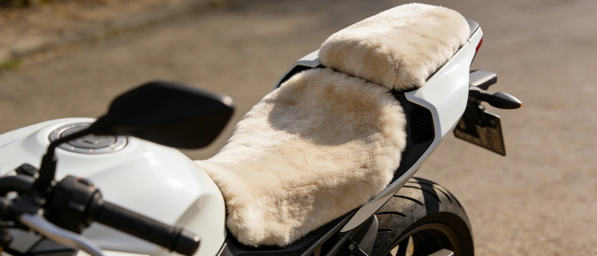 Premium sheepskin motorcycle seat cover neatly fitted on a modern motorcycle seat, showing soft texture and comfortable design